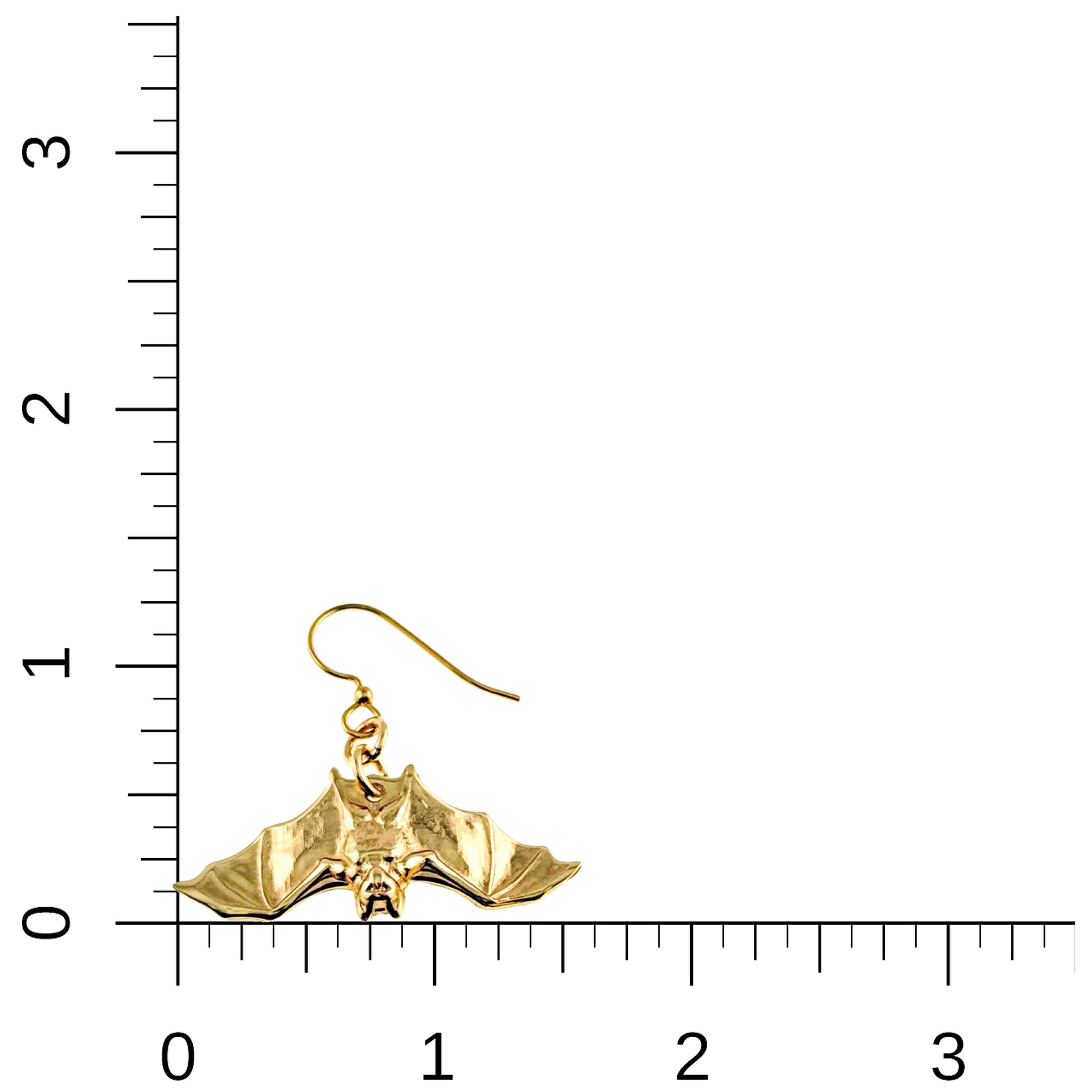 5 of 7: Gold bat-shaped earring on a ruler for scale