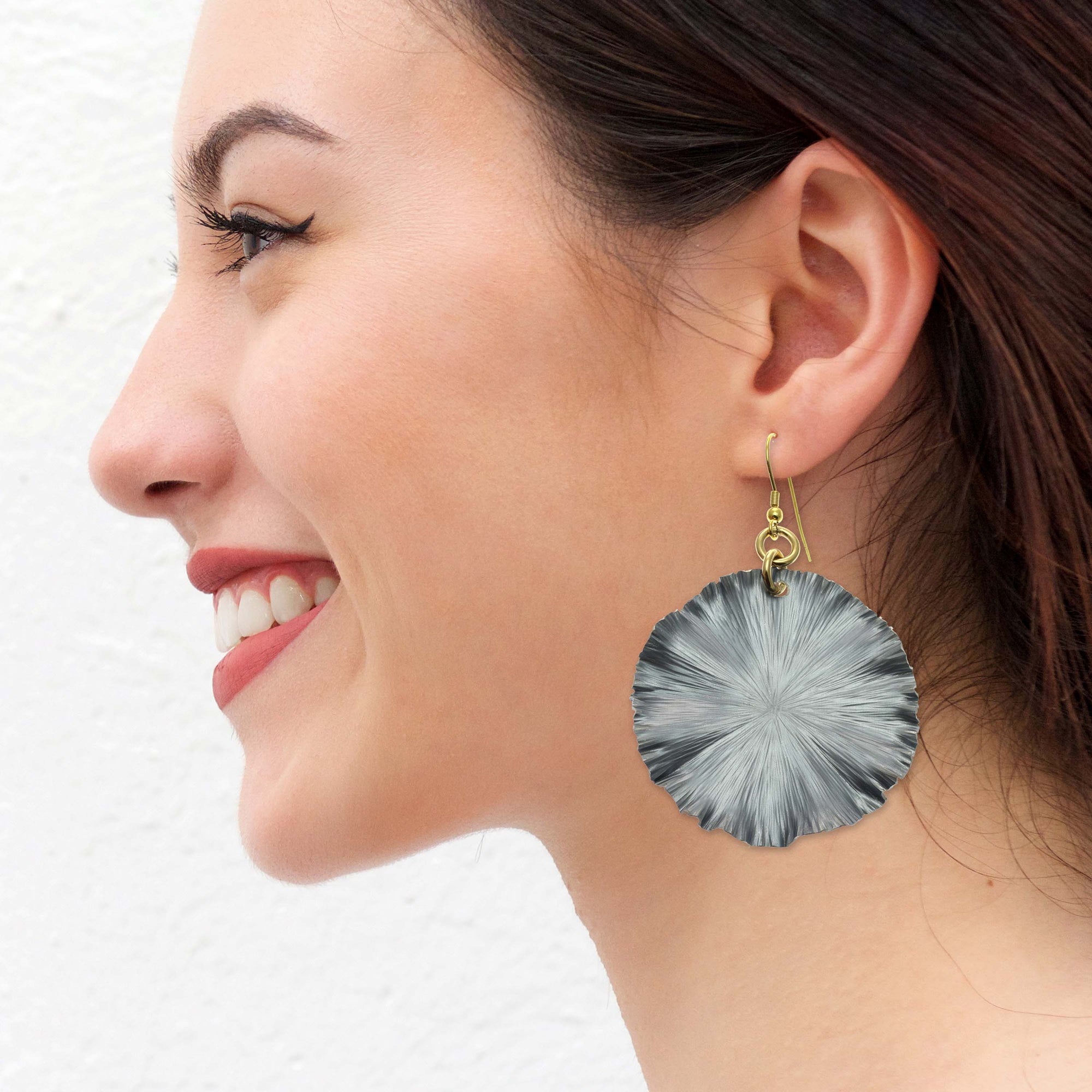 Smiling Woman Wearing Large Lily Pad Anodized Aluminum Pewter Gray Leaf Earrings