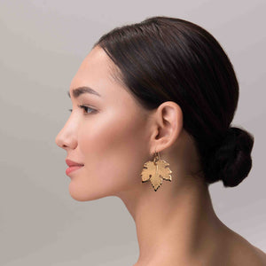 6 of 7: A Sophisticated Woman Wearing Large Maple Leaf Bronze Dangle Earrings