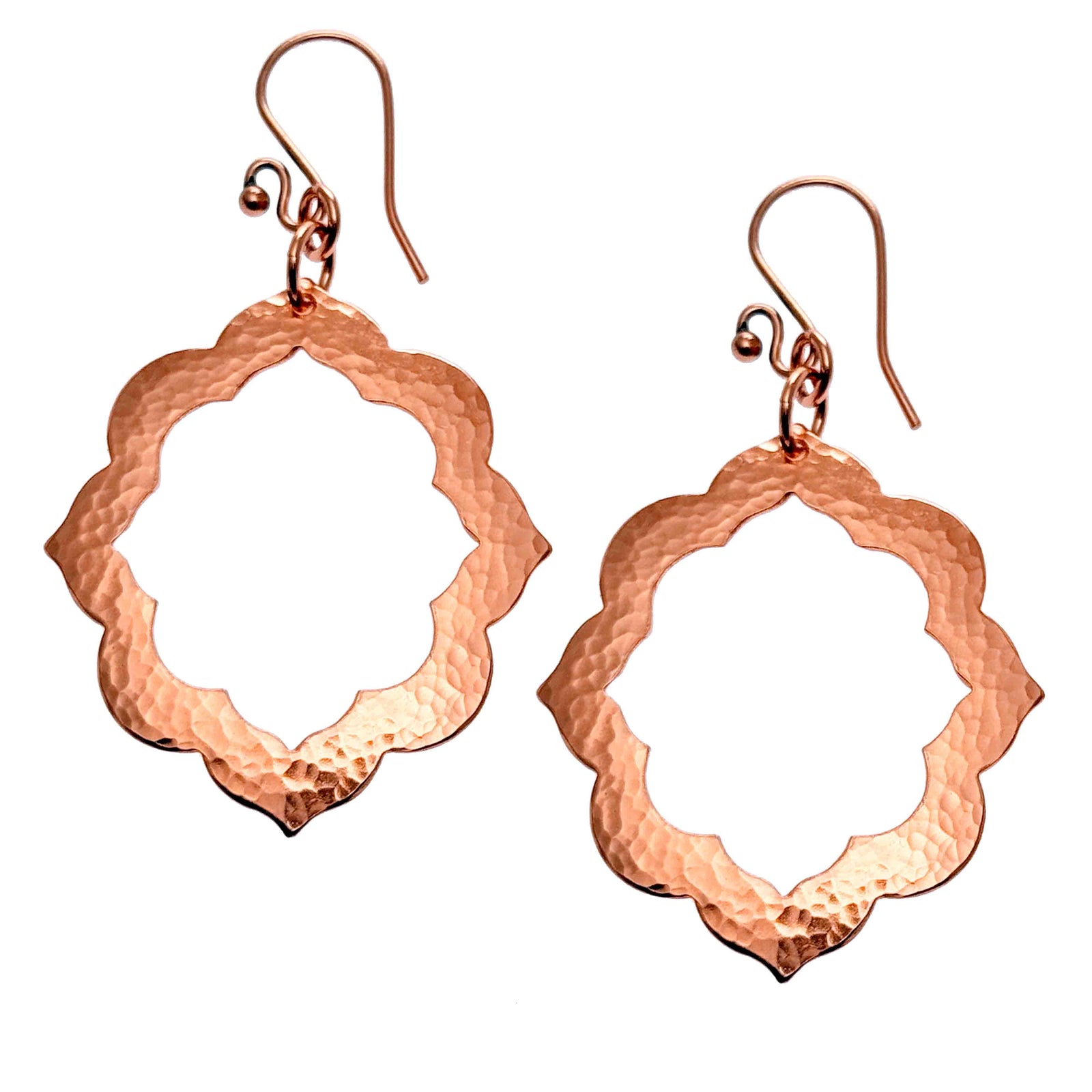 A Pair of Large Pierced Hammered Copper Arabesque Flower Earrings on a White Background