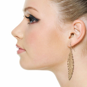 5 of 7: Elegant Woman Wearing Long Feather Bronze Drop Earrings