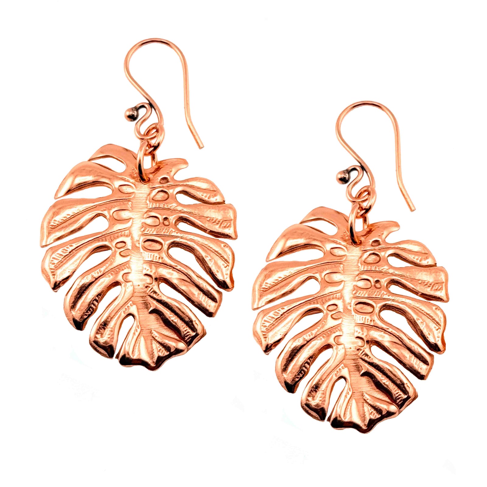 A Pair of Monstera Copper Leaf Earrings on a White Background
