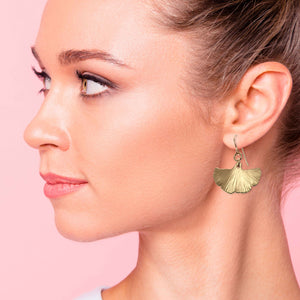 5 of 7: Stylish woman wearing bronze ginkgo leaf drop earrings.