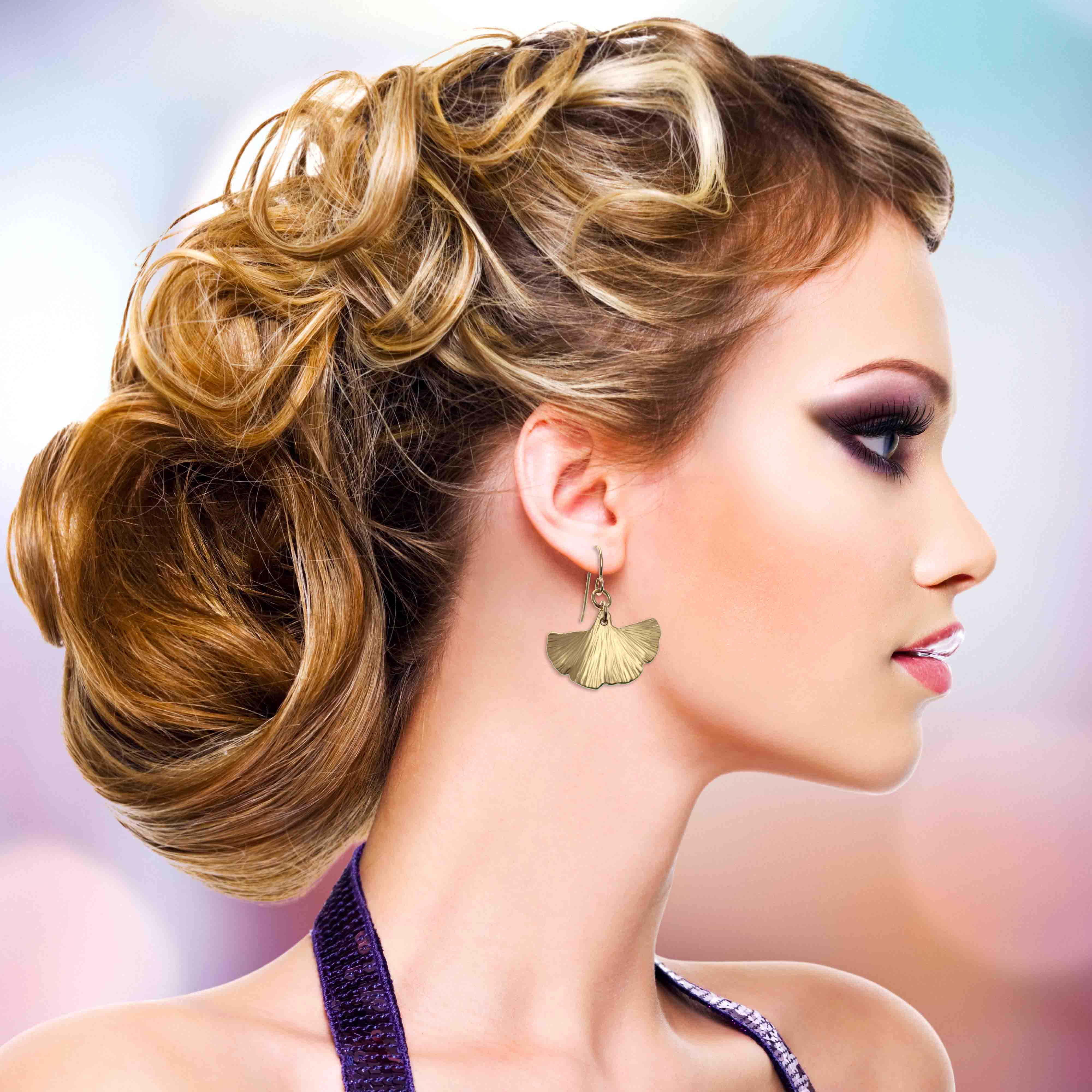 2 of 7: Elegant woman wearing bronze ginkgo leaf earrings, styled updo.