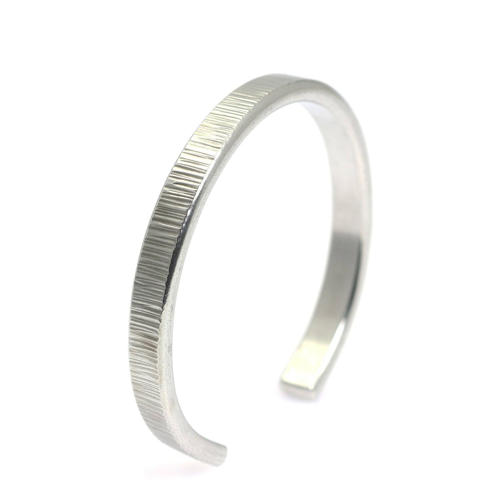 A Thin Chased Aluminum Cuff Bracelet on a White Background