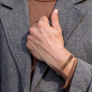 2 of 9: 10mm Wide Men's Embossed Mosaic Solid Copper Cuff on Male Model's Wrist Wearing Gray Sportscoat