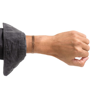 5 of 9: 10mm Wide Men's Embossed Mosaic Solid Copper Cuff on Male Model's Wrist Wearing Gray Shirt