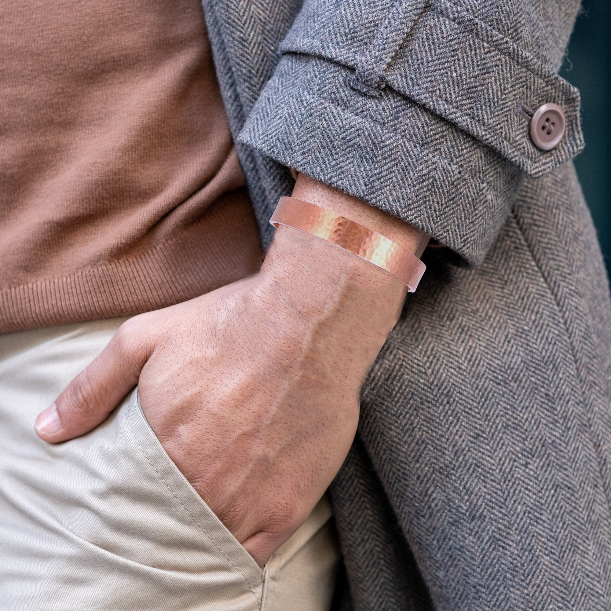 10mm Wide Hammered Copper Cuff Bracelet on Male Wrist Wearing a Gray Coat