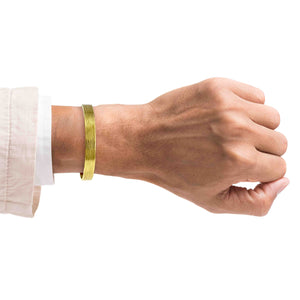 2 of 9: A Man's wrist wearing a 10mm Wide Bark Nu Gold Tone Brass Cuff Bracelet on a white background