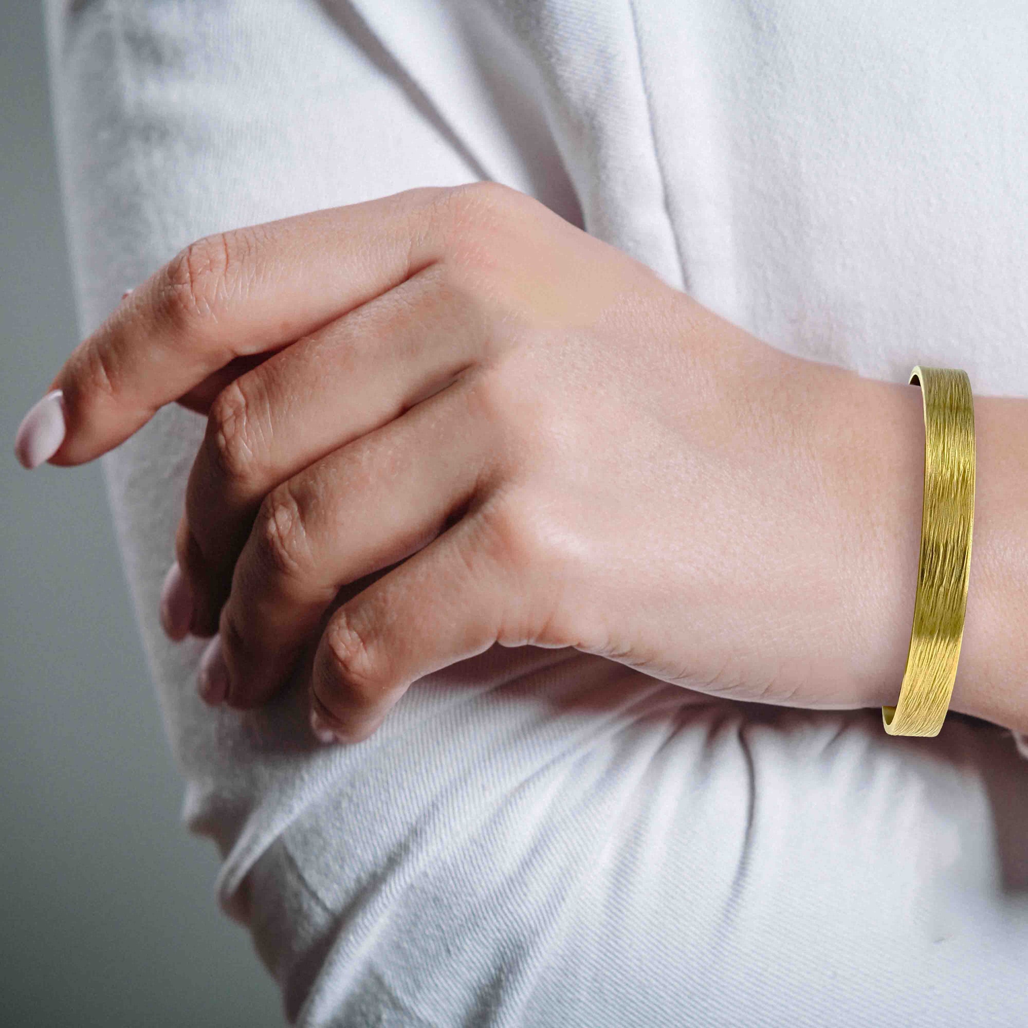 10mm Wide Bark Nu Gold Tone Brass Cuff Bracelet on a woman's wrist with a neutral background