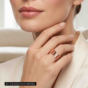 8 of 9: Close up of a woman wearing a wide hammered copper cuff ring on her finger, featuring a polished finish and open design. Her hand rests gently against her chin, highlighting the ring’s warm tone and textured surface, paired with soft neutral clothing for an elegant, modern look.  AI Generated Model.