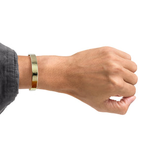 2 of 9: A Man's wrist wearing a 10mm Hammered Nu Gold Brass Cuff Bracelet on a white background