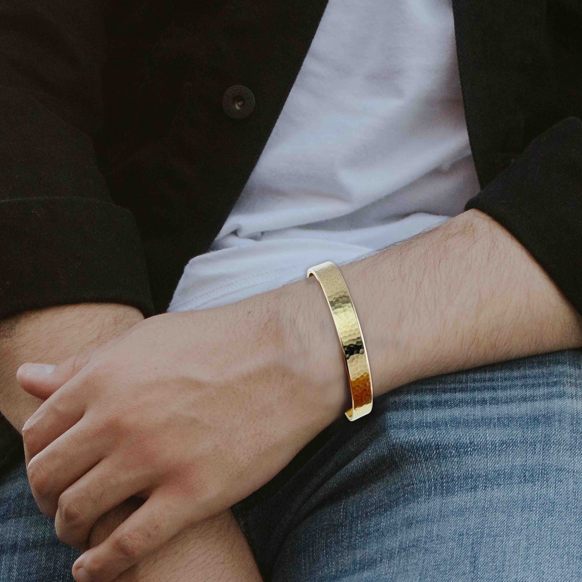 10mm Hammered Nu Gold Brass Cuff Bracelet  on a man's wrist with a blurred background