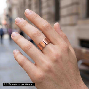 2 of 9: Close-up of a hand wearing a matte copper cuff ring with a wide open band design, featuring a smooth brushed finish and warm reddish tone, worn on the middle finger against a softly blurred city street background.  AI Generated Model.