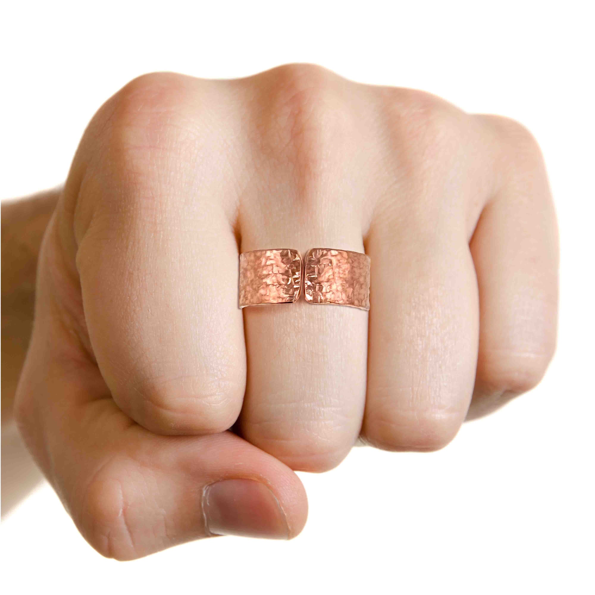 Hand wearing a 10mm Texturized Copper Cuff Ring on a white background