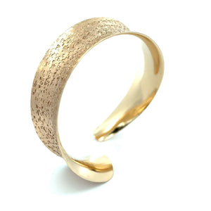 1 of 7: A 14K Gold Texturized Anticlastic Bangle Bracelet on a White Background