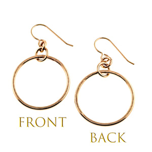 3 of 8: Front and back views of 1 inch hammered bronze hoop earrings on a white background. The polished circular hoops show subtle hand hammered texture, small bronze connecting rings, and French ear wires. Gold text beneath the earrings labels the front and back views.