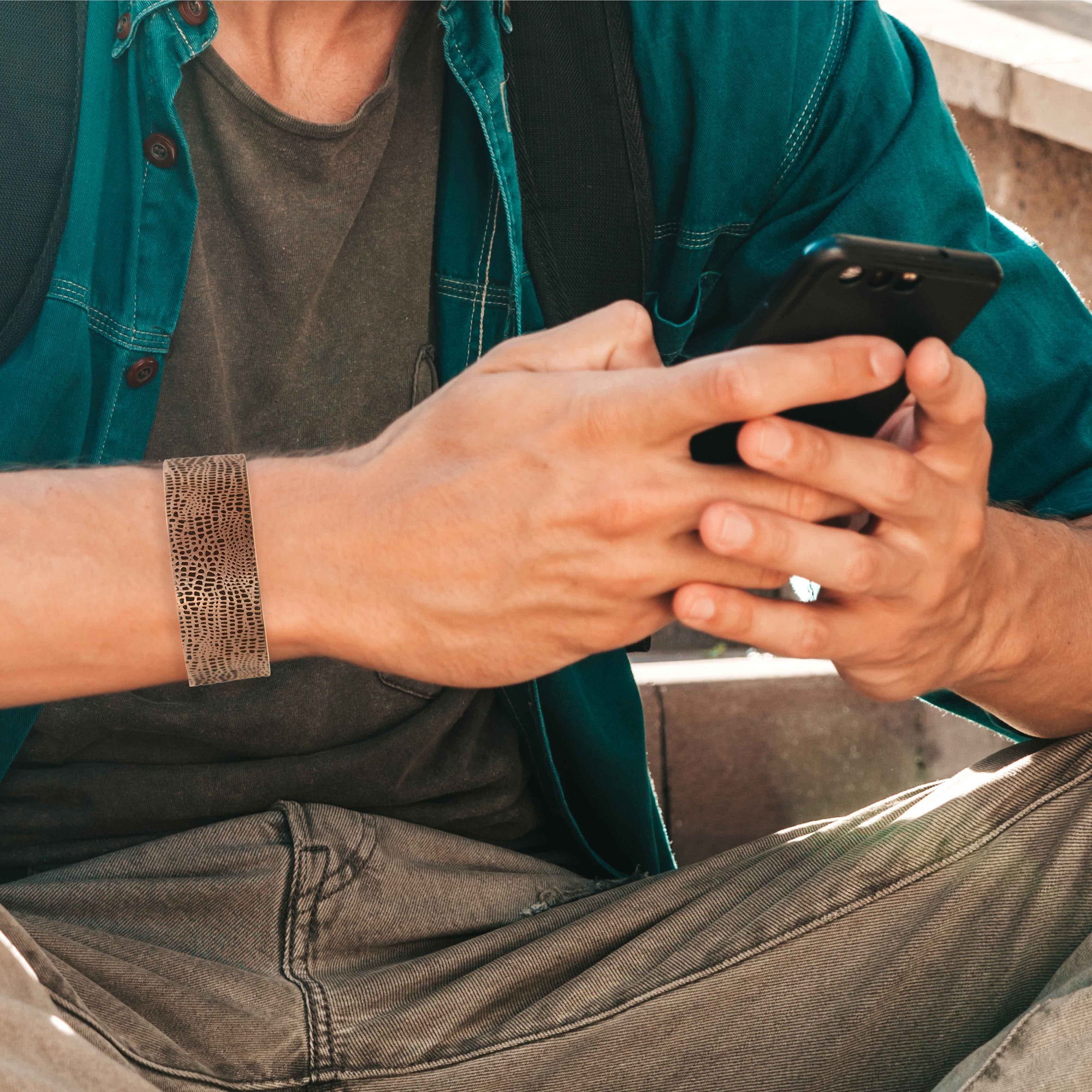 Man Looking at Cellphone Wearing Alligator Embossed 1 Inch Wide Solid Copper Cuff 