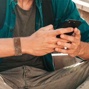 6 of 9: Man Looking at Cellphone Wearing Alligator Embossed 1 Inch Wide Solid Copper Cuff 