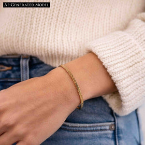 8 of 9: A close-up lifestyle photo of a woman wearing a slim 3.5mm bark-textured bronze cuff bracelet on her wrist. The bracelet shows a warm golden-bronze tone with a subtle organic texture. She is dressed casually in blue jeans and a soft cream knit sweater, highlighting the bracelet’s natural, everyday style and relaxed, modern look.  AI Generated Model.