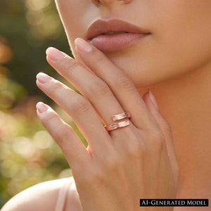8 of 9: Close up of a woman wearing a slim bark textured copper bypass ring on her finger. The open wrap design ends in two flat textured tips. Her hand rests near her face against a softly blurred outdoor background with warm green and golden tones.  AI Generated Model.