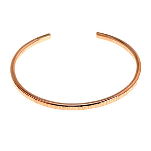 9 of 11: A minimalist raw copper cuff bracelet with a 3.5mm width and hand-chased texture, shown against a white background in an open, circular shape.