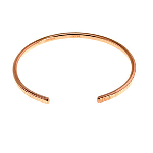 3 of 11: A handcrafted 3.5mm wide raw copper cuff bracelet with a chased texture, shown from above with its open-ended design and smooth, polished inner surface visible.