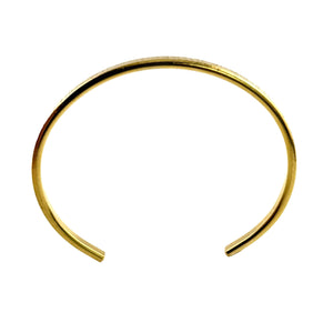 5 of 9: Front-facing view of a slim 3.5mm Nu Gold brass cuff bracelet with an open-ended design. The bracelet features a warm golden hue and a subtle chased texture along the outer edge, giving it a softly reflective finish. Displayed against a plain white background, the curved shape and minimalist style highlight its handcrafted, artisan quality.