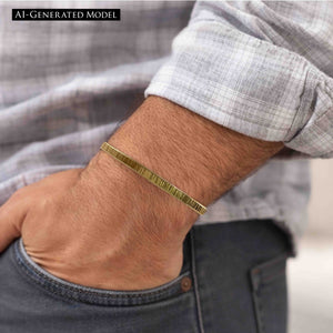 4 of 9: Close-up of a man's wrist wearing a 3.5mm chased Nu Gold brass cuff bracelet with a lightly textured, ridged finish. The bracelet has a warm golden tone and minimalist design. He is dressed in a light gray plaid shirt with dark jeans, and his hand is casually tucked into his pocket, showcasing the bracelet's laid-back yet refined look.  AI Generated Model.
