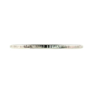 6 of 11: Detailed closeup of the John S. Brana 3.5mm Chased Stainless Steel Cuff Bracelet photographed horizontally against a white background. The narrow 316L surgical stainless steel band features irregular vertical chased marks that create alternating bright silver highlights and darker grooves. The close view emphasizes the handmade metal texture, 3.5mm width, and decorative surface that distinguishes this bracelet from a smooth cuff.