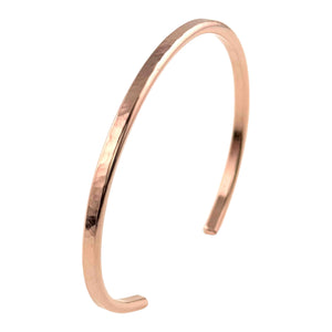 3 of 9: Slim, open-ended 3.5mm hammered copper cuff bracelet shown against a clean white background. The bracelet features a warm, polished raw copper finish with a subtle hand-hammered texture that reflects light along its curved surface. The minimalist cuff design includes smooth squared ends and an adjustable opening for easy wear, highlighting its handcrafted style suitable for everyday or dress occasions.