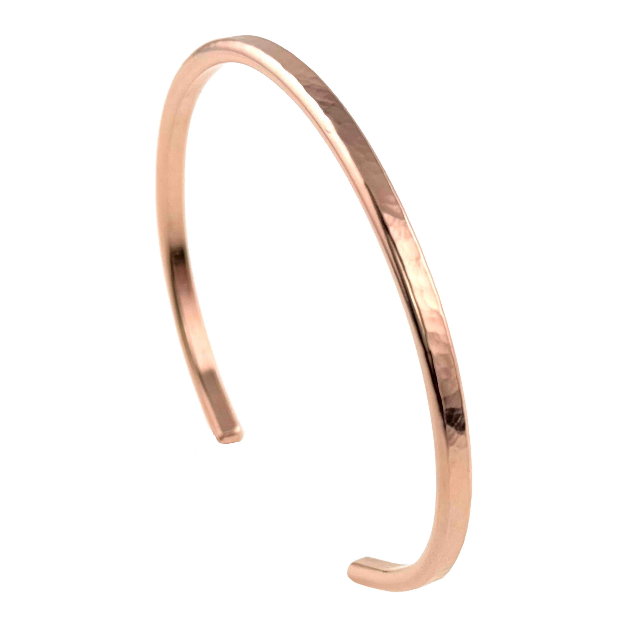 Slim 3.5mm hammered solid copper cuff bracelet displayed on a white background. The handmade open cuff has a warm rose-copper tone, narrow profile, smooth rounded ends, and polished edges. Its lightly hammered surface catches the light with subtle faceted reflections, highlighting the bracelet’s minimalist shape, handcrafted texture, and everyday copper jewelry style.