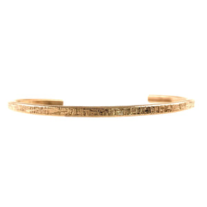 7 of 10: Side profile of a handcrafted 3.5mm linen bronze cuff bracelet showing its slim, flat band and detailed hand-hammered texture along the outer surface. The warm golden bronze finish is highlighted against a clean white background, emphasizing its minimalist shape and subtle linear pattern.