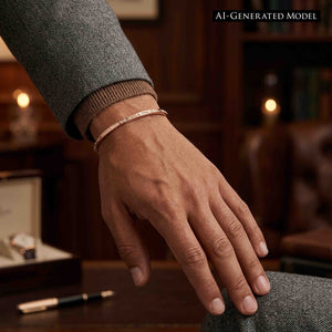 9 of 11: Close-up of a wrist wearing a slim solid copper cuff bracelet with a narrow 3.5mm width and subtle crosshatch linen texture. The open cuff sits neatly against the skin, paired with a gray jacket and ribbed cuff, set against a softly blurred warm indoor background.  AI Generated Model.