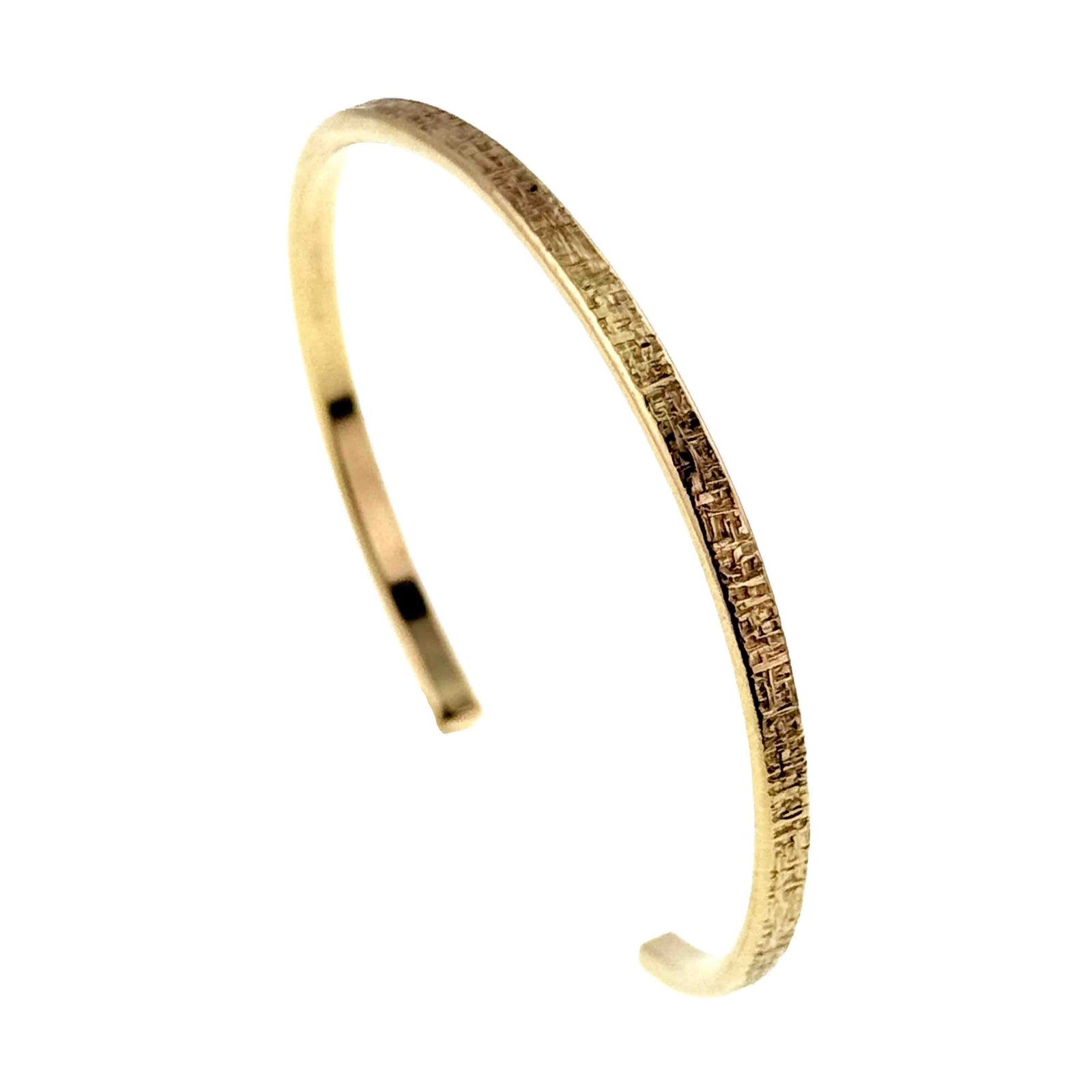 Side profile of the handmade 3.5mm Linen Nu Gold Brass Cuff Bracelet. The narrow solid Nu Gold Brass cuff features a polished interior and hand applied linen texture on the outer edge, showing its lightweight handcrafted construction.