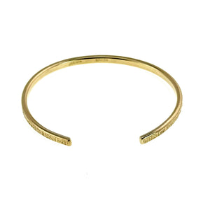 7 of 10: Opening view of the handmade 3.5mm Linen Nu Gold Brass Cuff Bracelet in solid raw Nu Gold Brass. The slim open cuff features a polished finish with a hand applied linen texture along the outer surface, highlighting its minimalist handcrafted design.