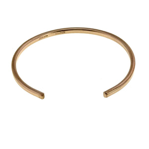 7 of 9: Top view of a handcrafted 3.5mm matte bronze cuff bracelet on a light gray background. The open cuff bracelet features a smooth rounded shape, brushed matte finish, and warm bronze color. Interior markings show the John S. Brana signature and bronze metal stamp.