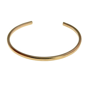 5 of 9: Front angled view of a slim matte bronze cuff bracelet with a softly brushed finish. The handcrafted solid bronze bracelet has a minimalist open cuff design with warm golden tones and a sleek narrow profile suited for everyday wear or anniversary gifts.