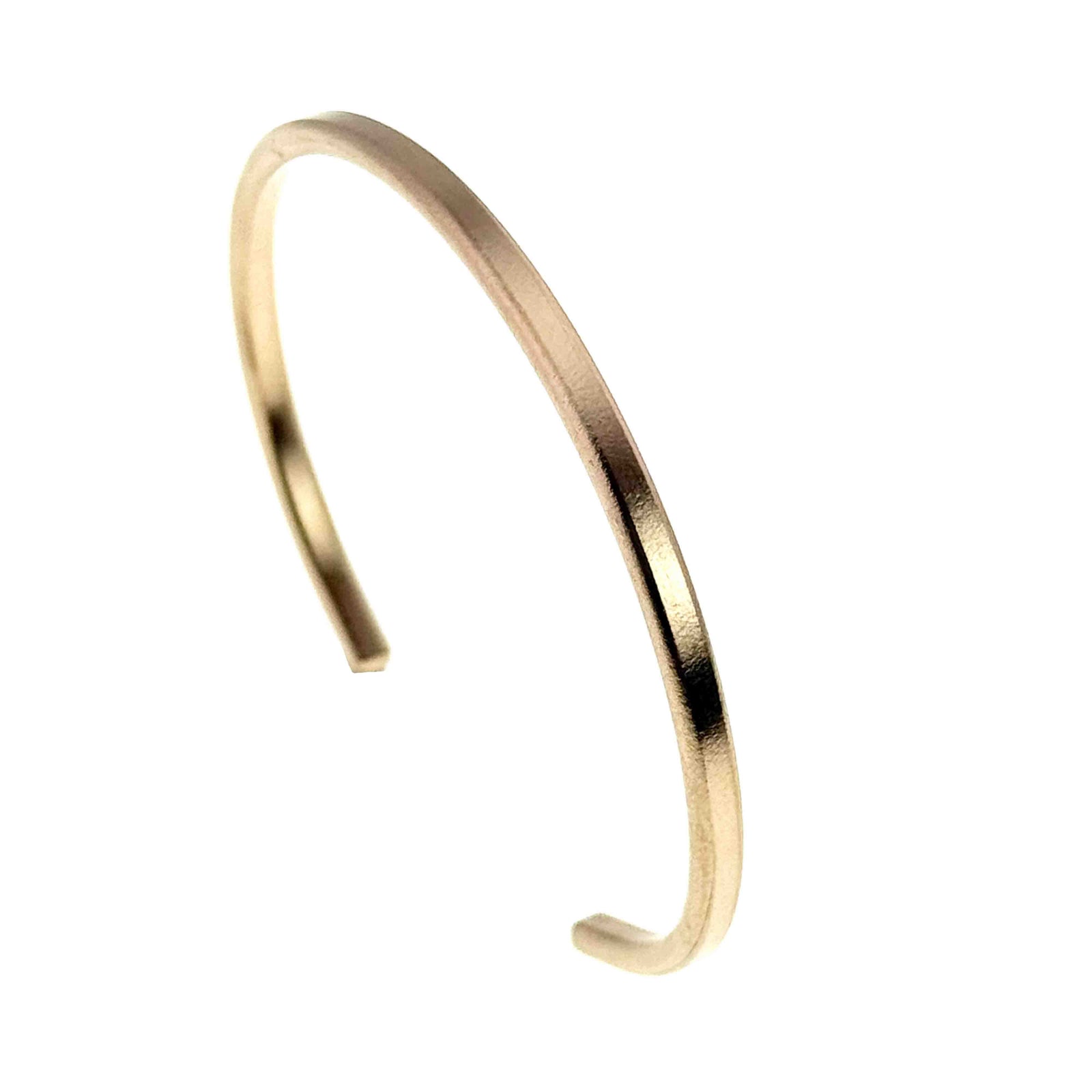3.5mm matte bronze cuff bracelet shown on a white background. The slim open cuff features a softly brushed matte finish with warm golden bronze tones. Handcrafted from solid bronze, the minimalist bracelet has a smooth rounded shape and narrow profile for modern everyday wear.