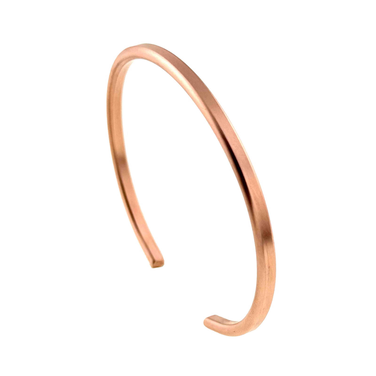 Matte copper cuff bracelet shown upright at an angle, highlighting the narrow band, smooth rounded edges, open design, and soft satin copper glow.