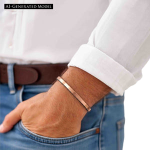 2 of 10: Matte copper cuff bracelet worn on a man’s wrist with a rolled white shirt sleeve, showing its narrow profile, warm copper tone, and casual polished style.  AI Generate Model.