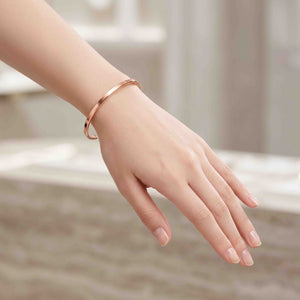 4 of 10: Slim matte copper cuff bracelet worn on a woman’s wrist, showing its delicate fit, warm copper tone, and simple everyday style against a soft neutral background.