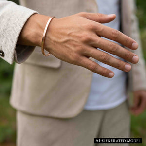 9 of 10: Matte copper cuff bracelet worn on a man’s wrist with a light jacket, showing its slim unisex style, warm copper finish, and easy casual look.  AI Generated Model.