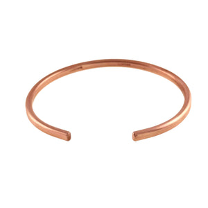 3 of 10: Low angled product view of the matte copper cuff bracelet, showing the open ends, rounded edges, slim band, and brushed raw copper finish on white.