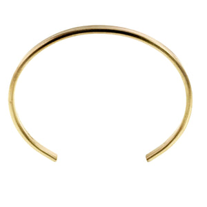 9 of 10: Direct overhead view of the 3.5mm matte Nu Gold brass cuff bracelet on a white background, showing its smooth oval form, narrow open ends, and warm hand brushed golden finish.