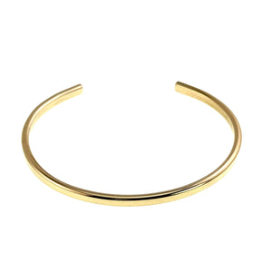 9 of 11: Front view of a slim polished Nu Gold brass cuff bracelet on a white background. The open ends face upward while the curved band displays its smooth golden surface and bright reflective finish.