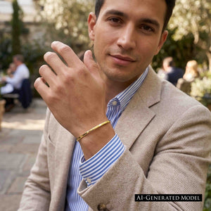 6 of 11: Man wearing a slim polished golden brass cuff bracelet with a striped shirt and beige jacket at an outdoor cafe. His raised wrist places the bracelet in clear view against the shirt cuff. A black label reads AI generated model.