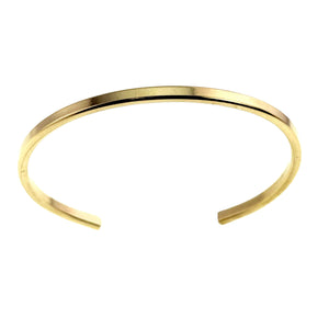 5 of 11: Polished Nu Gold brass cuff bracelet shown from above on a white background. The slim open cuff has a warm golden color, smooth mirror finish, gently rounded shape, and unfinished open ends facing forward.