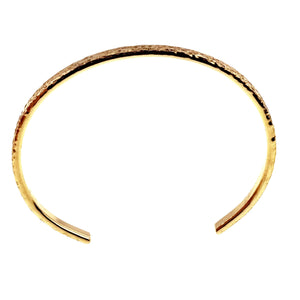 3 of 9: Top view of an open Nu Gold brass cuff bracelet on a white background. The image shows the full oval shape, narrow 3.5mm width, polished inner band, textured outer surface along the upper curve, and two smooth ends separated by the wrist opening.