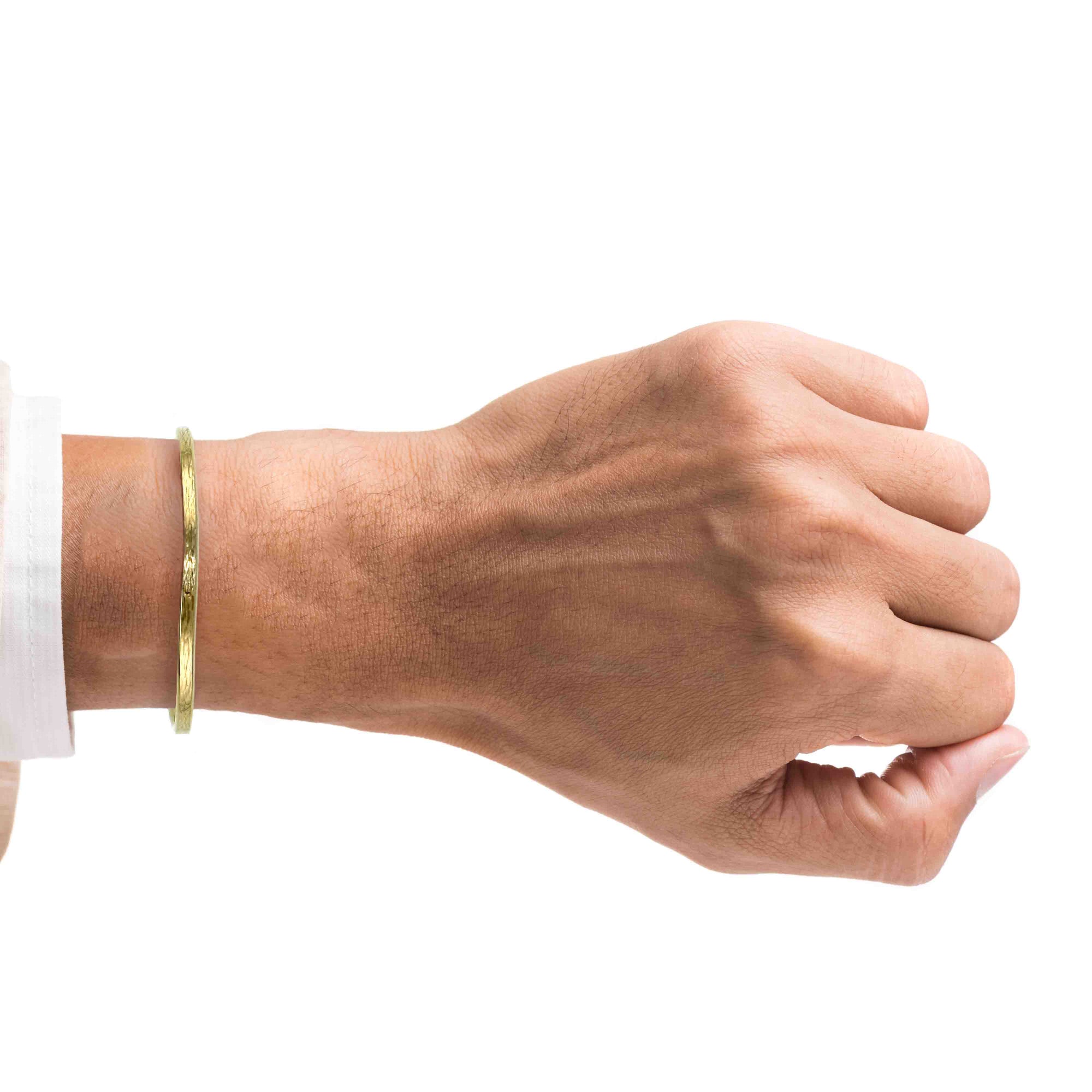 A Man's Wrist wearing a 3.5mm Bark Nu Gold Brass Cuff Bracelet on a white background